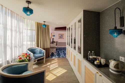 a living room with a blue chair and a table at Grand Swiss-Belhotel Melaka - formerly LaCrista Hotel Melaka in Melaka