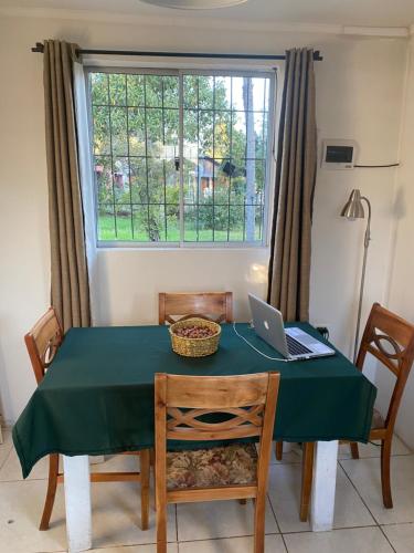 a dining room table with a laptop computer on it at Casa de Campo in Santa Cruz