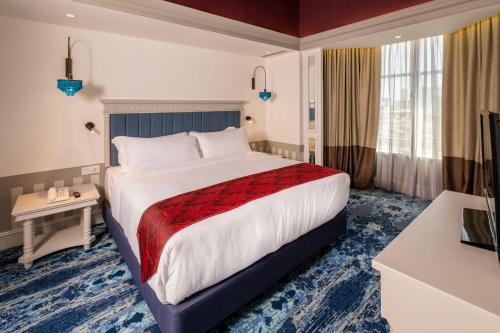 a hotel room with a large bed and a television at Grand Swiss-Belhotel Melaka in Melaka