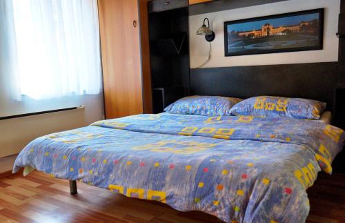a bed with a blue comforter in a bedroom at Marinac Apartment in Zagreb