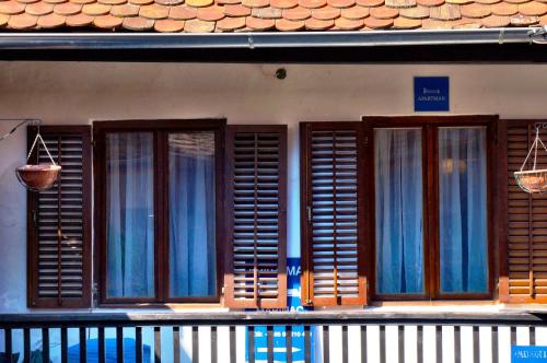 a group of windows with blue curtains on a building at Marinac Apartment in Zagreb