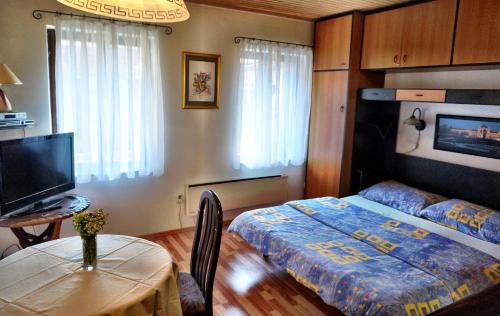 a bedroom with a bed and a table and a television at Marinac Apartment in Zagreb