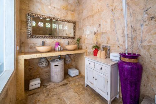 Baño con 2 lavabos y jarrón púrpura en Villa Armani Seminyak, en Seminyak