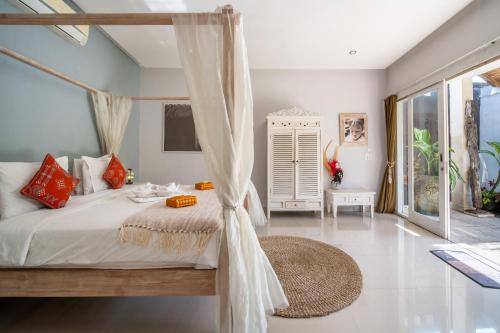 1 dormitorio con 1 cama con dosel en Villa Armani Seminyak, en Seminyak