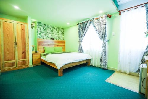 um quarto com uma cama e uma janela em Dalat Flowery hotel & coffee em Da Lat
