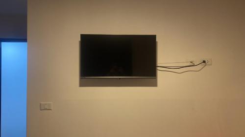 telewizor z płaskim ekranem wiszący na ścianie w obiekcie La Pascana Hospedaje w mieście Cajamarca