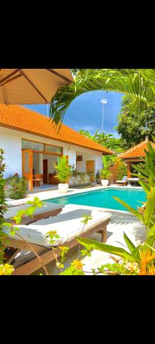 a swimming pool in front of a house at Villa Seruni Lovina in Lovina