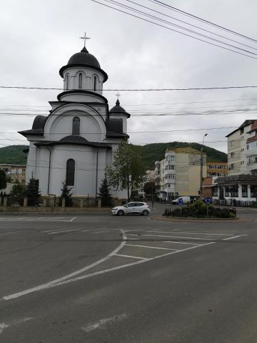 a white car parked in front of a church at Apartament ASR in Piatra Neamţ