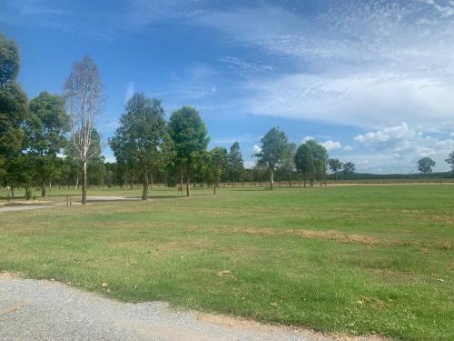 un campo de hierba con árboles a lo lejos en Standown Park Caravan retreat en Goomboorian