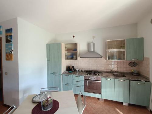 uma cozinha com armários azuis e uma mesa em Caorle & Caorle em Caorle