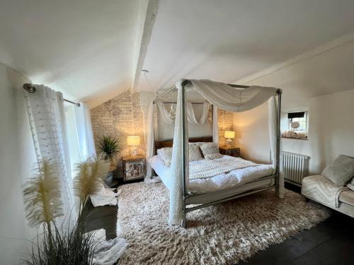 1 dormitorio con cama con dosel y alfombra en Coupling Cottage, en Belper