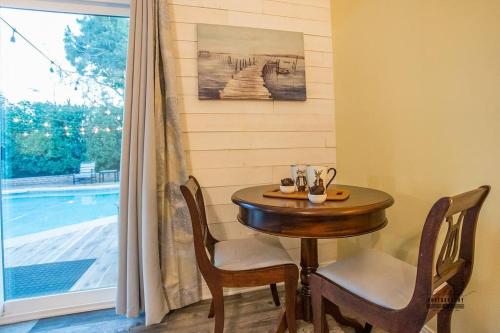a small table and chairs in a room with a window at Paso House in Redding