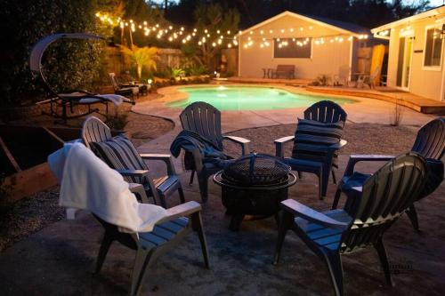 a group of chairs around a pool at night at Paso House in Redding
