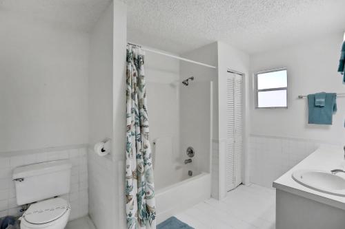 ein weißes Bad mit einem WC und einem Waschbecken in der Unterkunft Home on St Johns River in Atlantic Beach