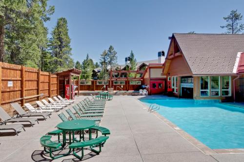 a resort with a swimming pool with lounge chairs at Pine Ridge Condos in Breckenridge