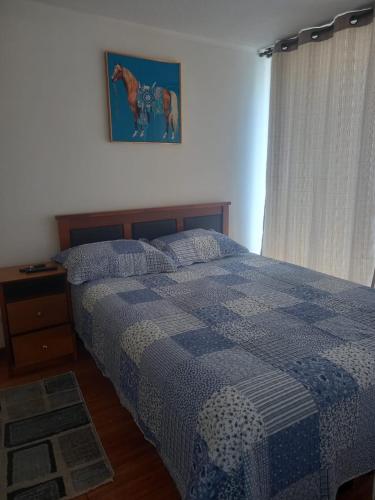 a bedroom with a bed and a picture of a horse on the wall at Departamento Santiago centro in Santiago
