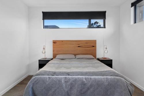 a bedroom with a large bed and two lamps at Amongst The Tea Trees in Inverloch