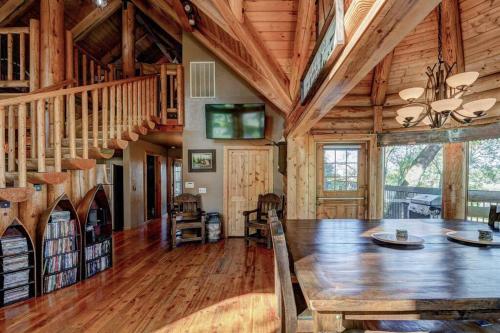 uma sala de jantar com uma grande mesa de madeira e escadas em Happy Bear Lodge - Luxury 4 BR Cabin em Shasta Lake