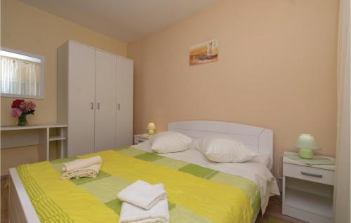 Schlafzimmer mit einem Bett mit gelber Bettwäsche und weißen Kissen in der Unterkunft Beautiful Apartment In Orebic With 2 Bedrooms And Wifi in Orebić