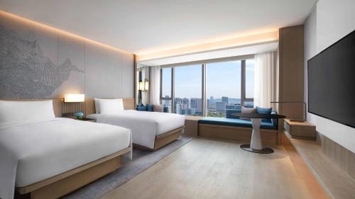 南京市にあるCourtyard by Marriott Nanjing Jiangningのベッド2台と薄型テレビ付きのホテルの部屋