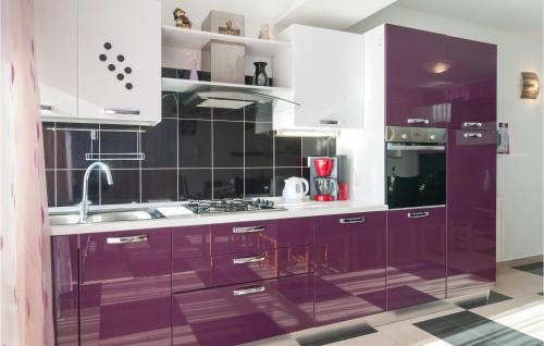 a kitchen with purple cabinets and a sink at Awesome Home In Zrnovnica With 6 Bedrooms, Wifi And Outdoor Swimming Pool in Žrnovnica
