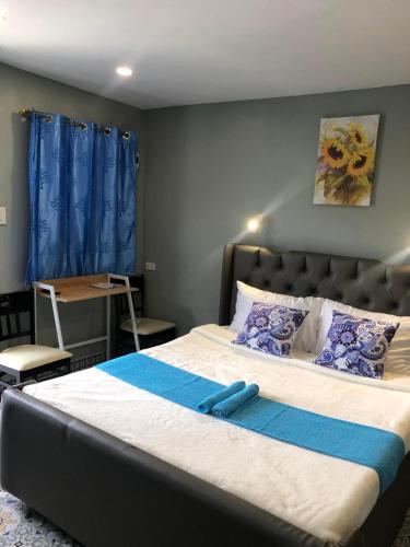 a bedroom with a large bed with blue pillows at D Sanctum Resort in General Santos