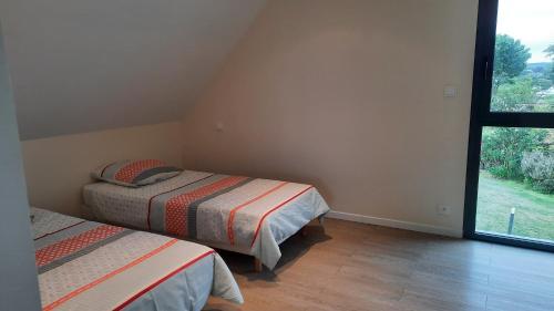 sypialnia z 2 łóżkami i dużym oknem w obiekcie Pleneuf Val André Appart Vue MER 2 Chambres w mieście Pléneuf-Val-André