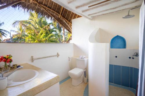 y baño con aseo y lavamanos. en Aestus Villas Resort, en Diani Beach