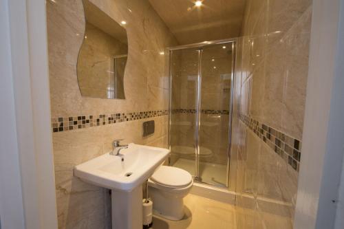 a bathroom with a toilet and a sink and a shower at Royal London Hotel By Saba in London