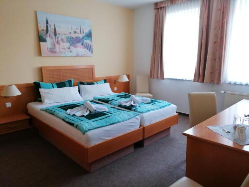 une chambre d'hôtel avec un lit et une table dans l'établissement Hotel Garni zum Goldenen Ring, à Quedlinbourg