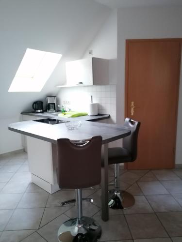 a kitchen with a table and two bar stools at Hotel Garni zum Goldenen Ring in Quedlinburg