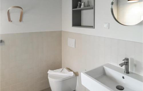 a bathroom with a toilet and a sink and a mirror at 2 Bedroom Cozy Home In Warthe in Warthe