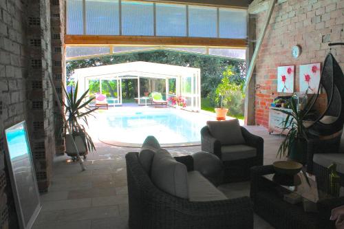 a living room with a swimming pool in a house at La Ferme de Bellune in Mazères