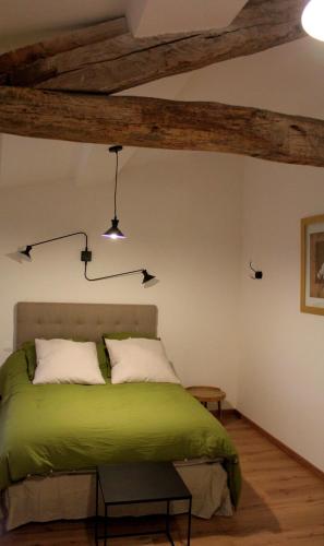 MazèresにあるLa Ferme de Belluneのベッドルーム1室(緑のベッド1台、木製の梁付)