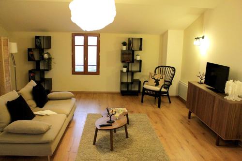 a living room with a couch and a table at La Ferme de Bellune in Mazères