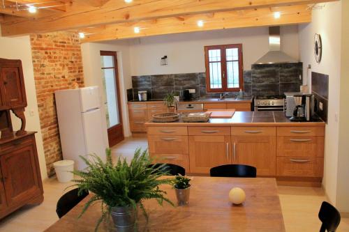 MazèresにあるLa Ferme de Belluneの木製キャビネットとテーブル付きの広いキッチンが備わります。