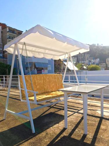 a swing bed with a white canopy on a roof at Joen Apartments in Sarandë