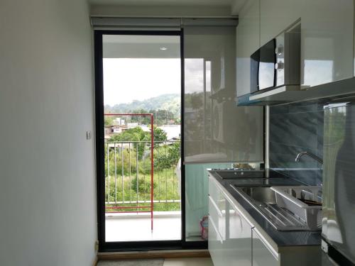 a kitchen with a sliding glass door to a balcony at 4 Floor - Centrio Condominium in Phuket town in Phuket