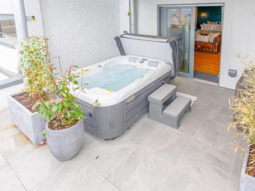 a hot tub on a patio with potted plants at Cuillin Studio - Ukc6562 in Mallaig