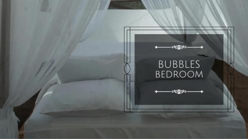 a bed with a sign that reads bubbles bedroom at SIOSAR PUNCAK 2000 Cottage kacinambung in Pertibi