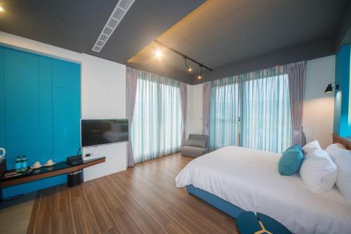 1 dormitorio con 1 cama grande y TV en sunlight mound, en Yuanshan