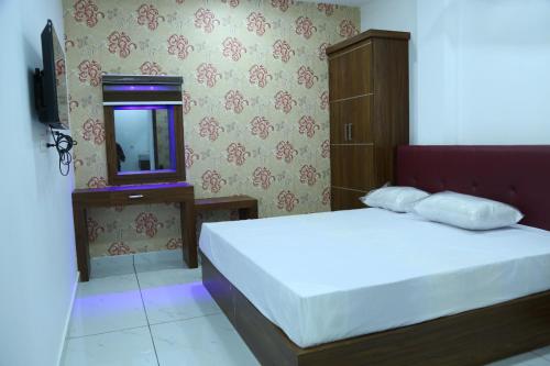 a bedroom with a bed and a mirror and a television at Kurianplackal Residency in Alwaye