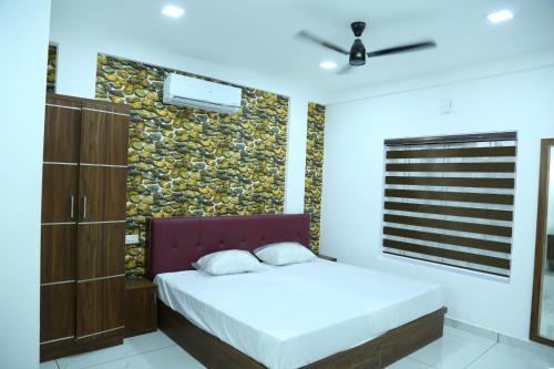 a bedroom with two beds and a stone wall at Kurianplackal Residency in Alwaye