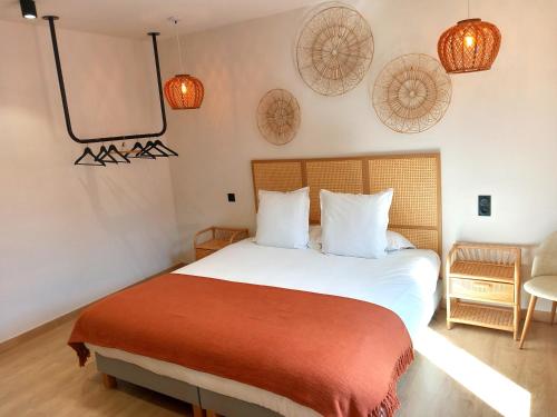 una camera con un letto bianco e una coperta rossa di Intense Boutik-Hôtel a Port-Vendres
