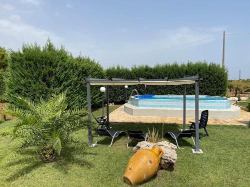 een tuin met een prieel en een zwembad bij Country House in San Vito dei Normanni