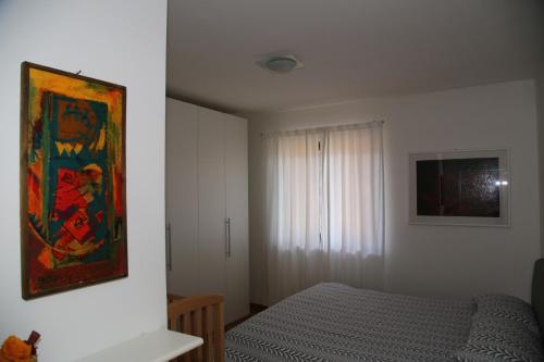1 dormitorio con 1 cama y una pintura en la pared en Relax e natura vicino a Trento, en Montagnaga