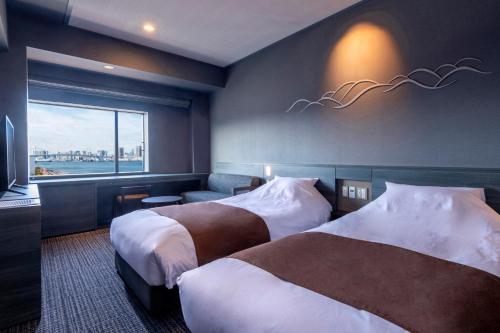 東京にあるラビスタ東京ベイのベッド2台と窓が備わるホテルルームです。