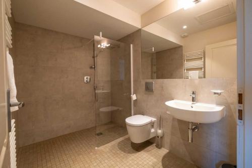 ein Bad mit einem Waschbecken, einem WC und einer Dusche in der Unterkunft Domaine de la Durantie - Villas avec Spa de nage in Castelnau-de-Montmiral