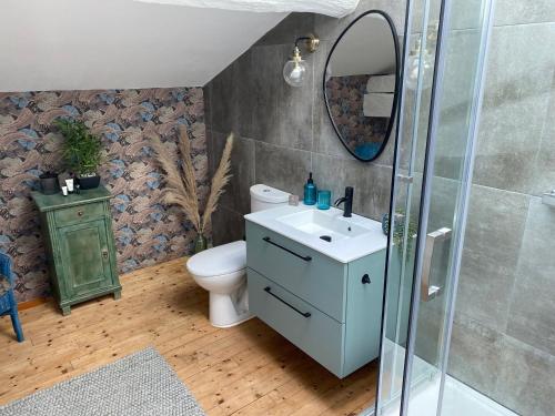 a bathroom with a sink and a toilet and a mirror at Figtrees in Margueron