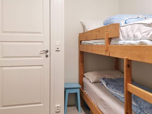 a bedroom with a bunk bed with a blue stool at Holiday home TØRRVIKBYGD II in Tyrvikbygd